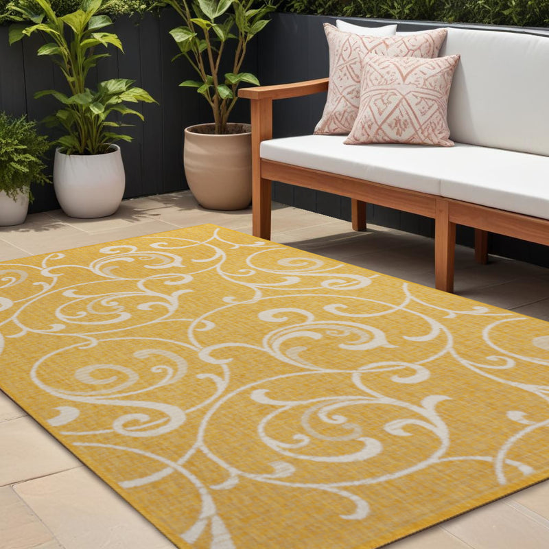 Yellow area rug with cream scroll-and-swirl pattern