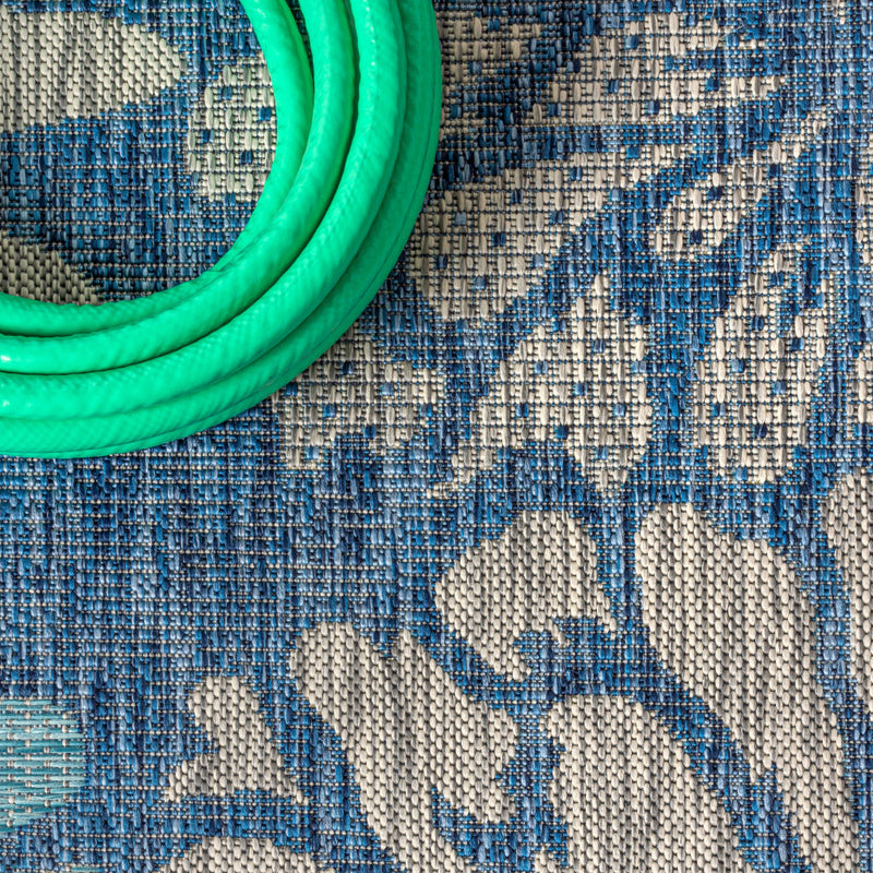 Blue rug texture with cream floral pattern and tightly woven surface