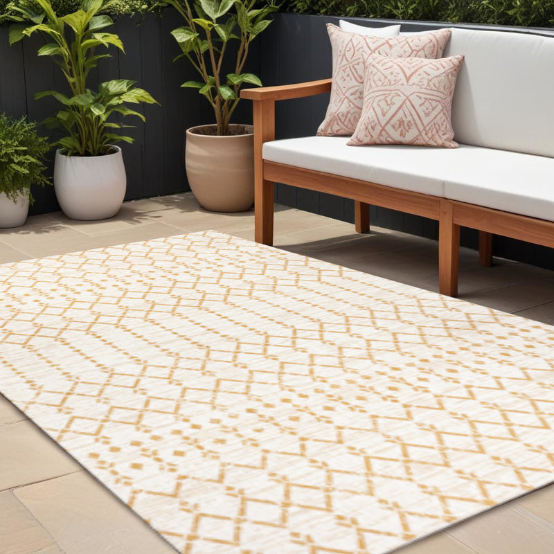 Indoor outdoor area rug with cream ground and yellow geometric trellis diamond pattern