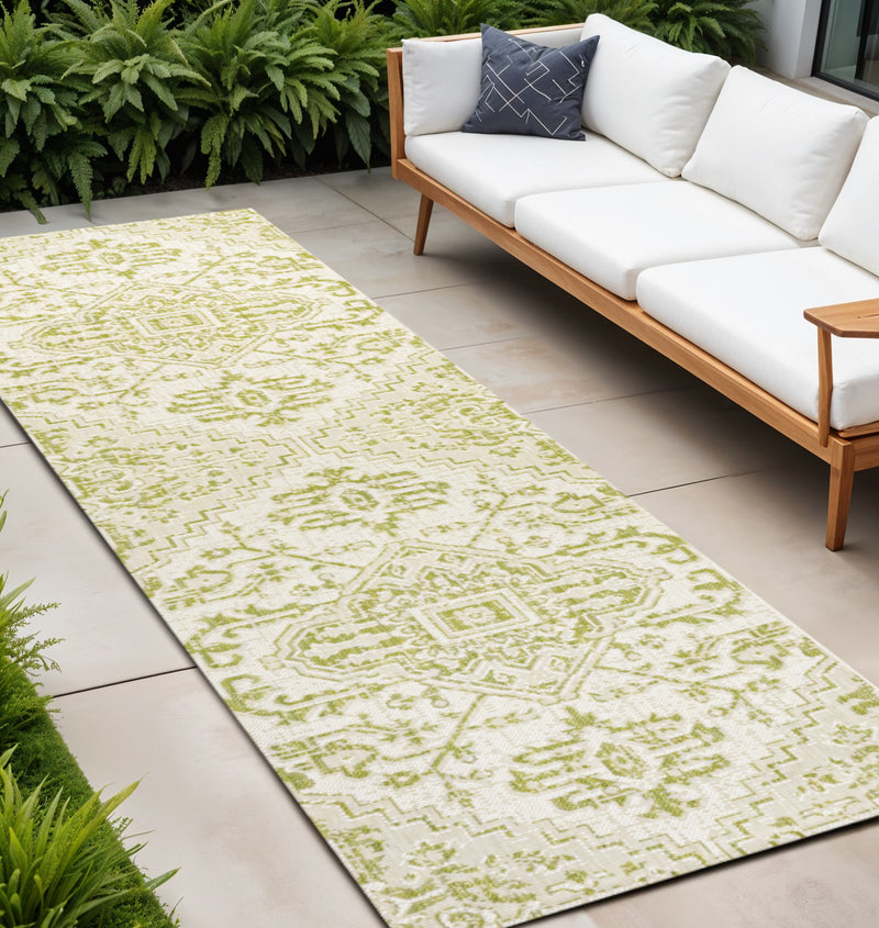 Cream and green medallion indoor outdoor runner rug on patio floor