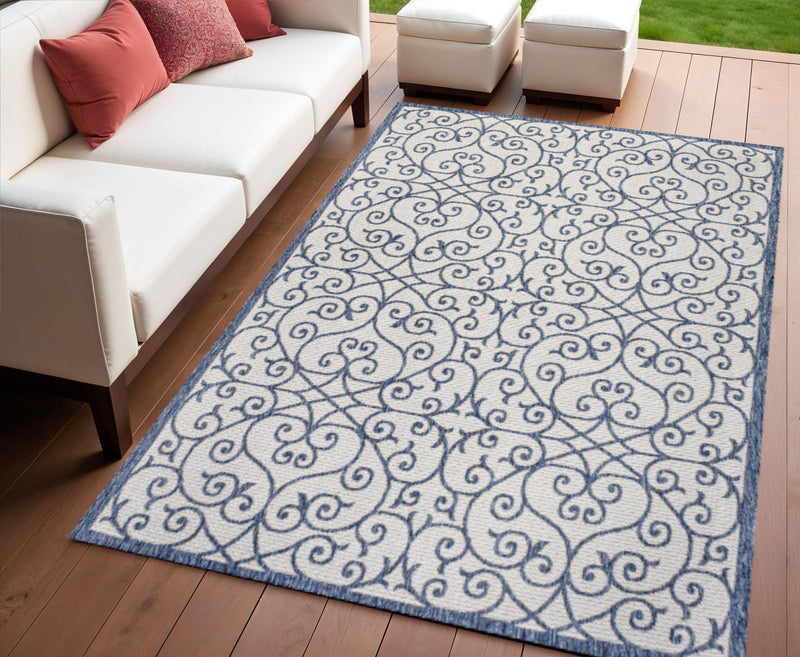 Geometric scroll area rug in navy and beige with bordered edge