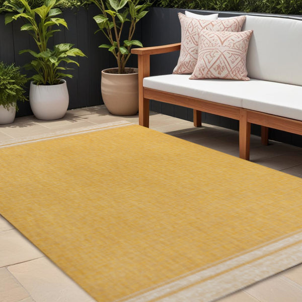 Yellow and cream indoor/outdoor area rug with woven texture and cream border, 8x10 ft