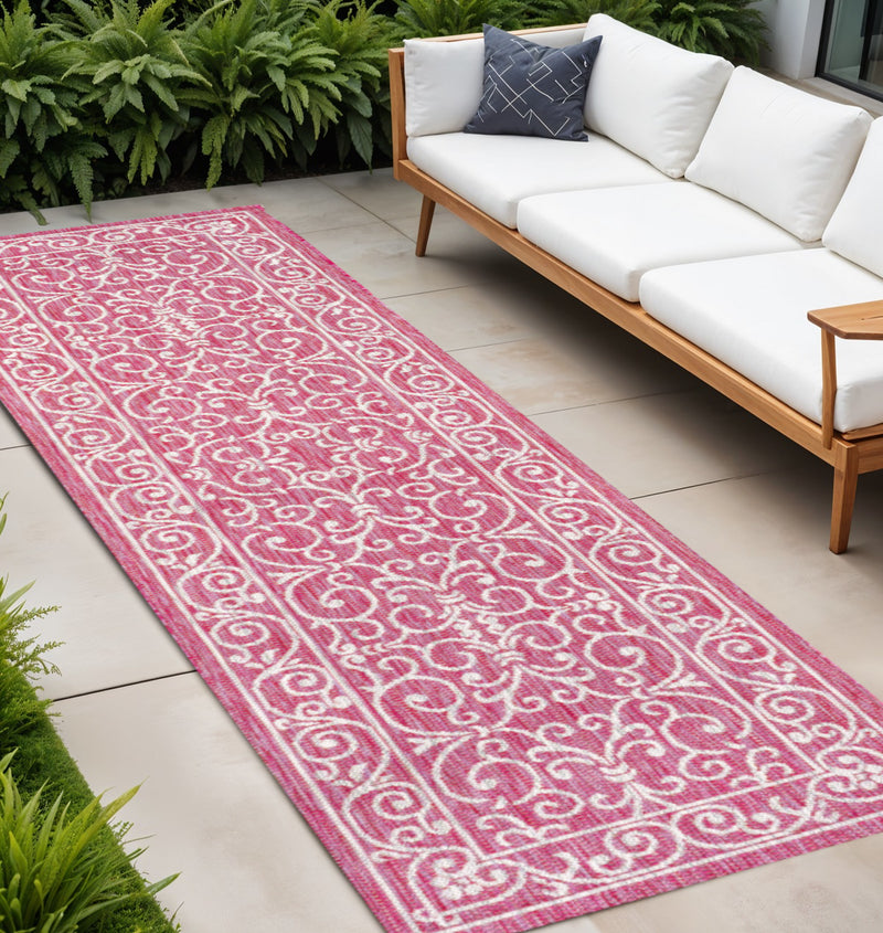 Fuchsia indoor outdoor runner rug with light gray ornate scrolling pattern and border