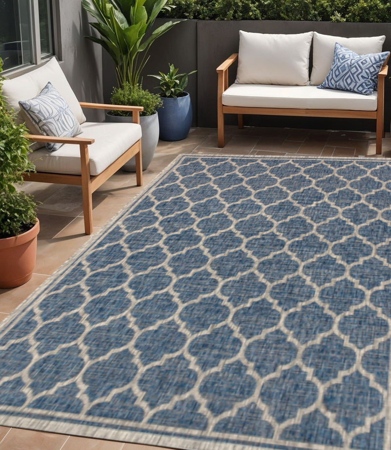 Outdoor area rug with blue and gray geometric lattice pattern, woven flat surface.