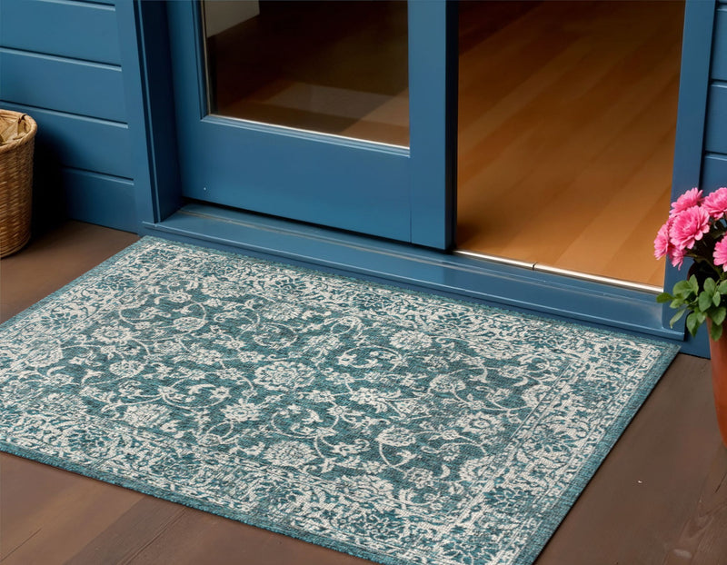 Teal blue and gray medallion indoor/outdoor area rug with ornate border pattern.