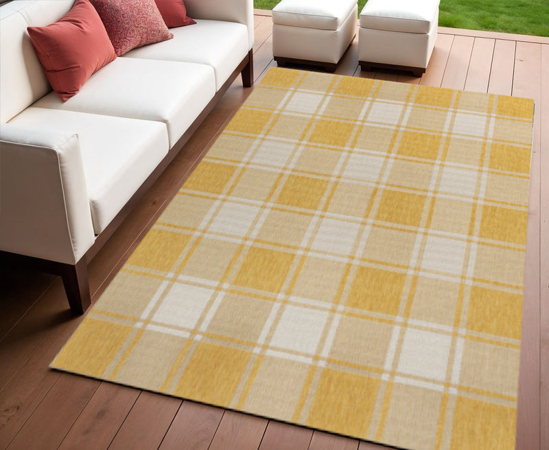 Yellow and cream gingham area rug with plaid grid, on hardwood floor.