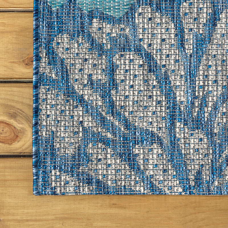 Navy and aqua floral runner rug edge with dotted multicolor weave and border