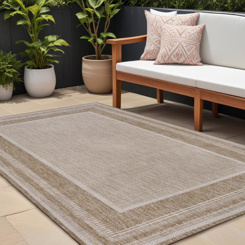 Beige and cream area rug with wide border stripes and central textured panel