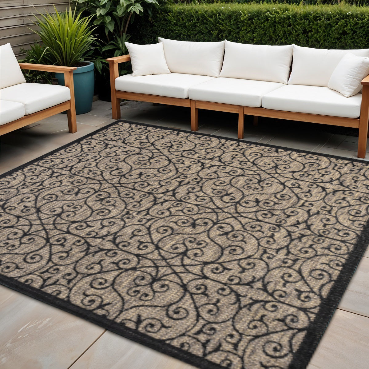 Indoor outdoor area rug with ornate geometric scroll pattern and dark border