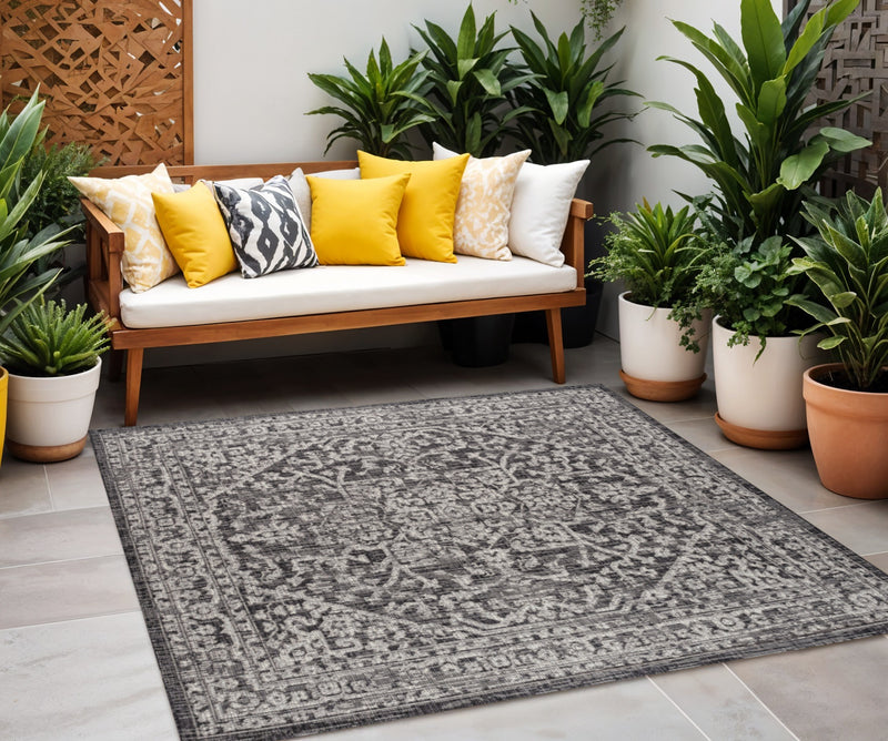 Black and gray patterned square medallion area rug in outdoor seating setting