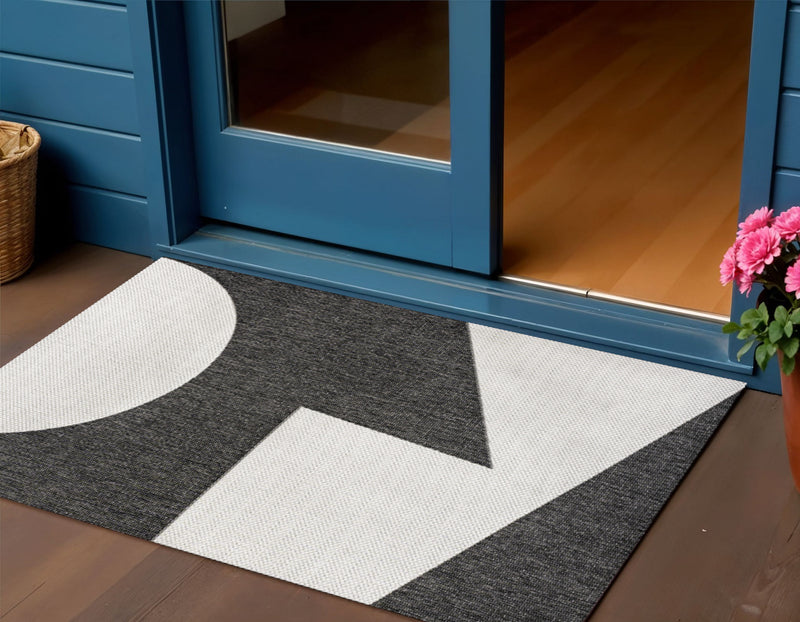 Black and cream geometric area rug on floor with centered square pattern