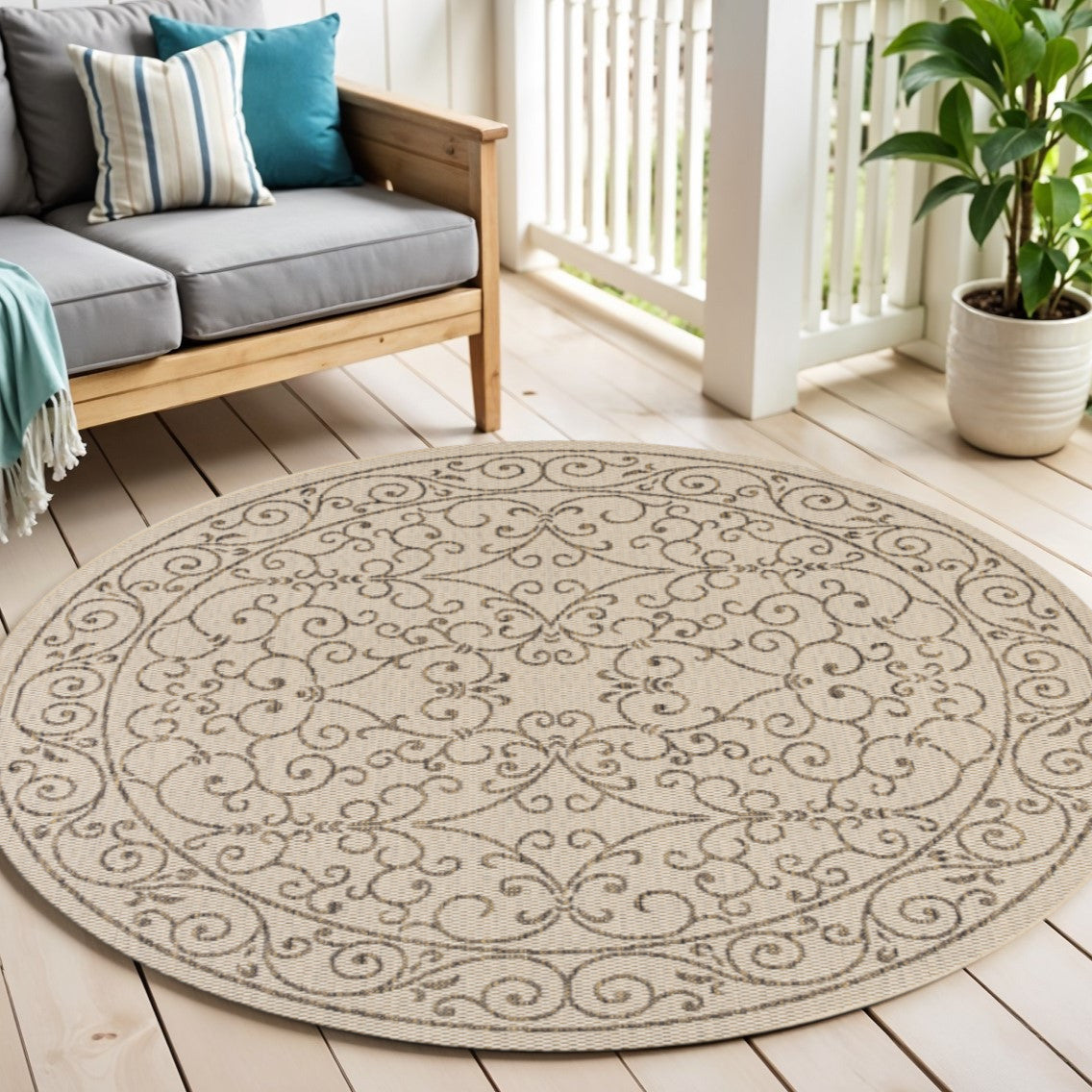 Round beige rug with brown scroll medallion on light wood floor indoors