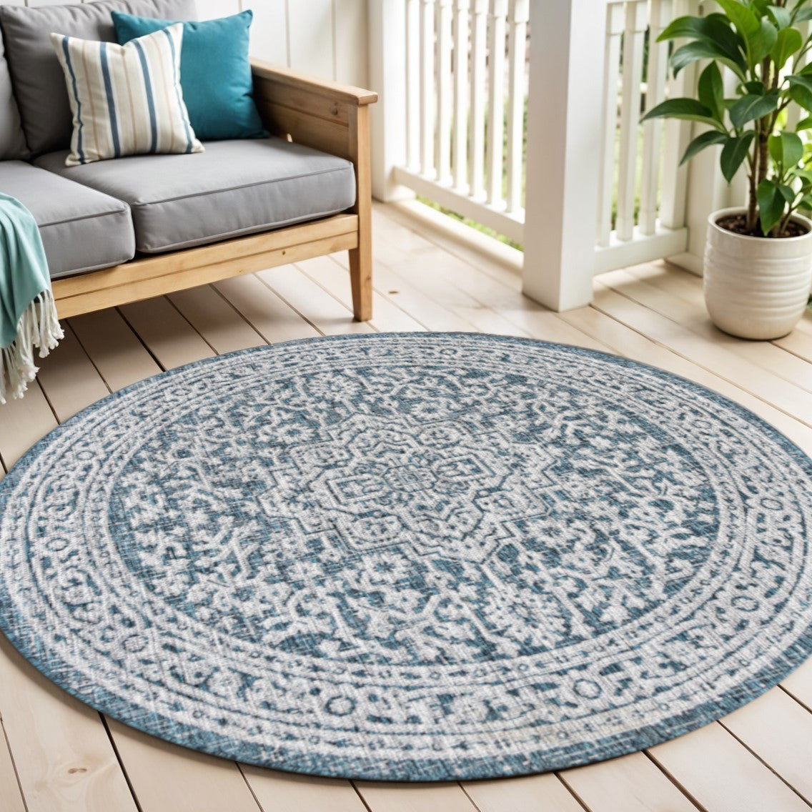 Round area rug with blue and gray medallion pattern and teal border in living space