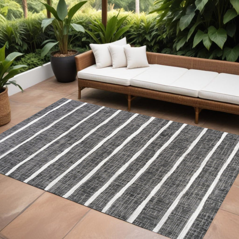 Indoor/outdoor area rug with wide black and ivory stripe pattern.