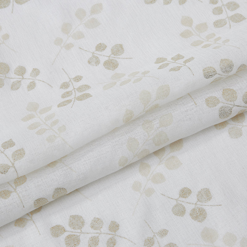 White shower curtain with repeating gold flower and leaf pattern on textured fabric