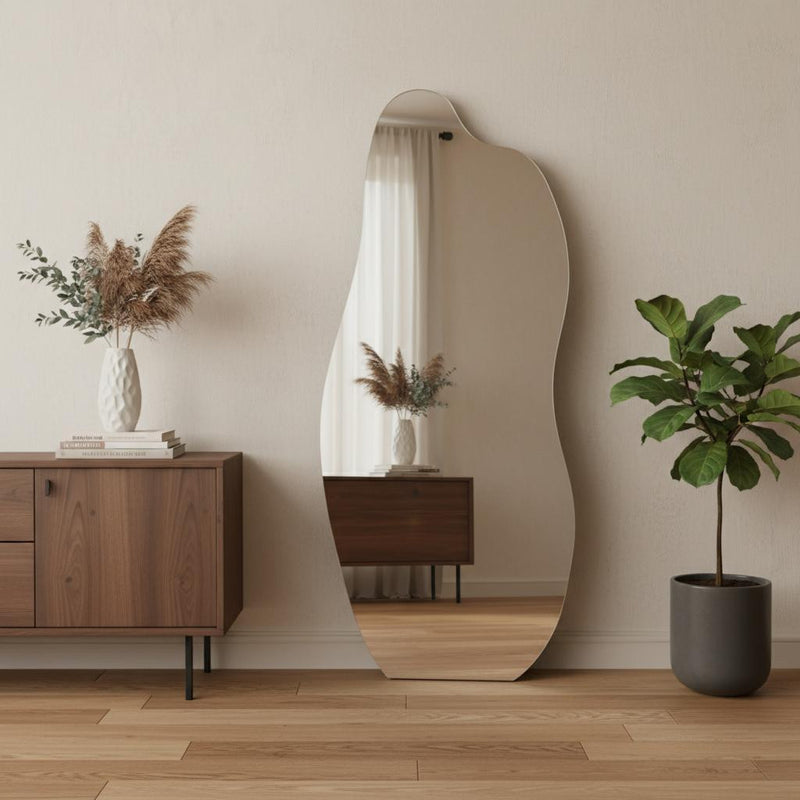 Clear abstract frameless mirror, rounded top wavy outline, freestanding