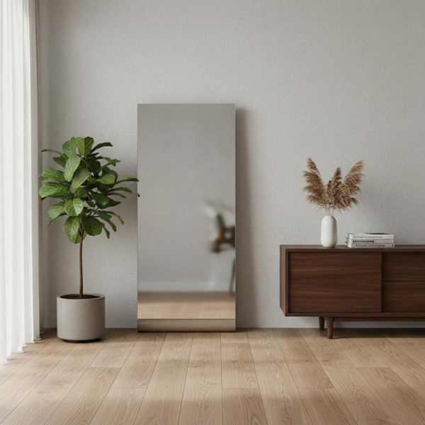 Leaning frameless accent mirror with dark brown bottom support, full-length standing
