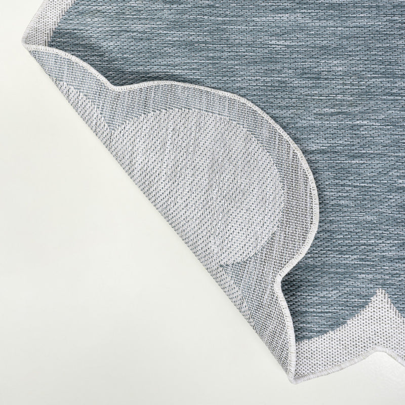 Turquoise runner rug corner with cream border trim and dense, textured weave
