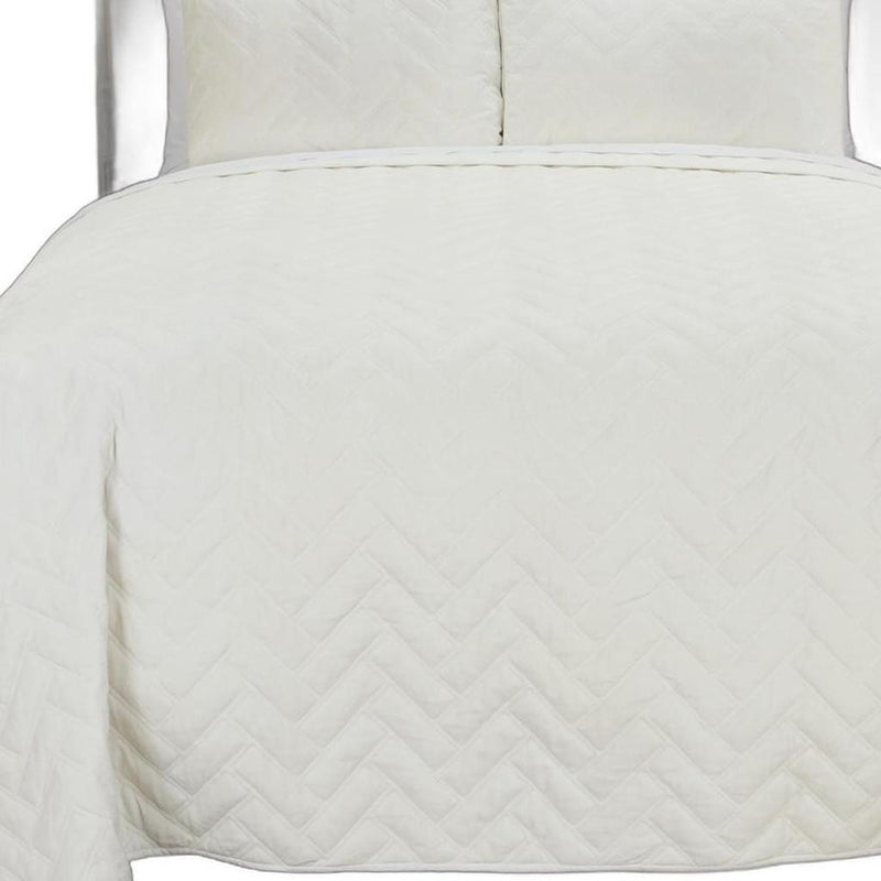 Chevron-quilted cotton quilt with textured zigzag pattern, off-white