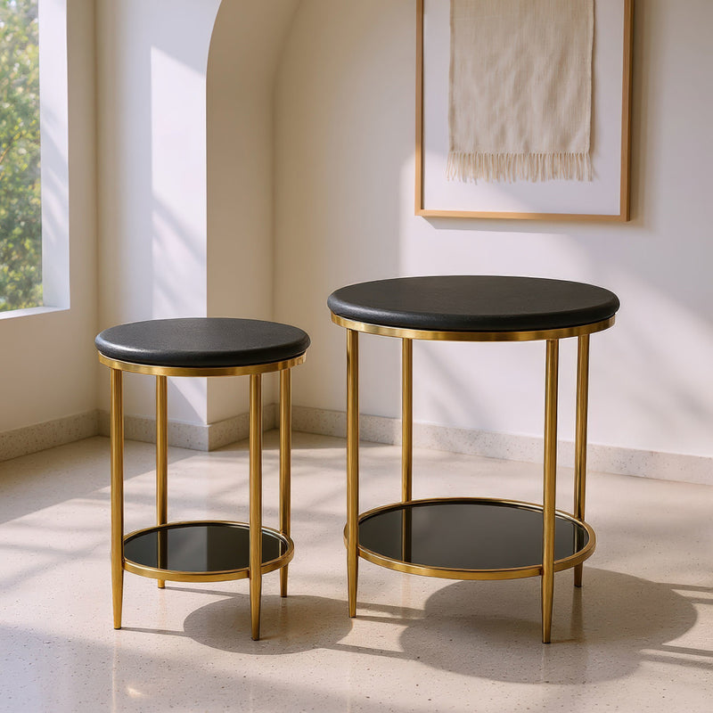 Two round black-top side tables with gold legs and open bottom shelf, outdoor light