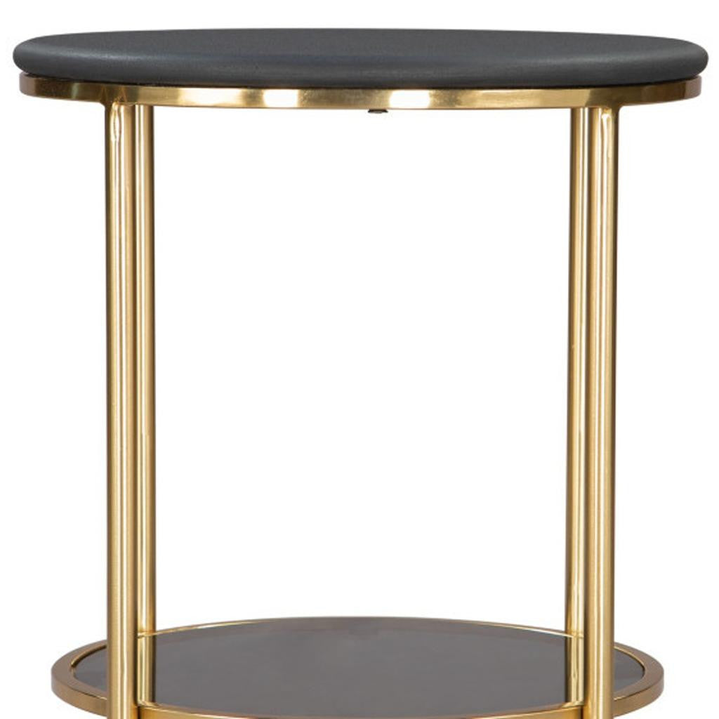 Round black-top side table with gold legs and circular open lower shelf