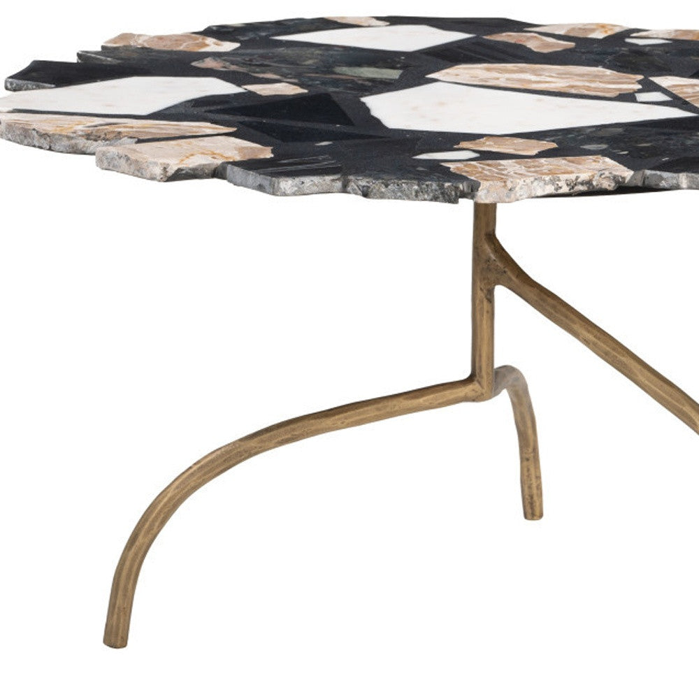 Black and white terrazzo mosaic coffee table with gold flecks and curved iron pedestal base