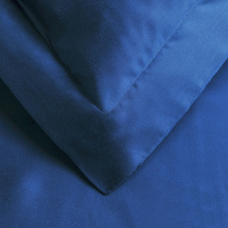Blue duvet cover corner with V-fold and stitched trim, close-up