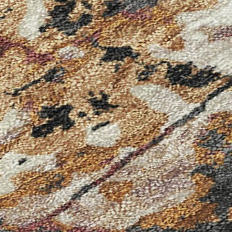 Abstract rug close-up of cream and charcoal shapes with orange-brown speckled wear.
