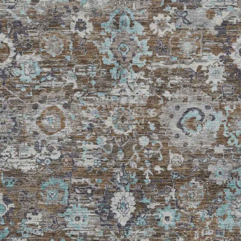 Pattern detail of indoor outdoor area rug with teal blue and brown distressed motifs on gray