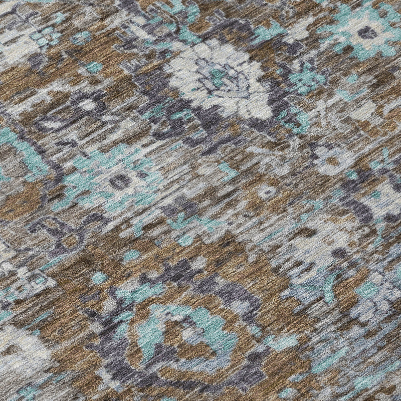 Close-up of distressed floral area rug in gray, brown, and teal blue
