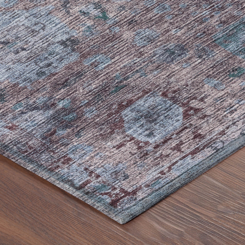 Corner view of abstract rug with blue-gray pile, plum tones, and teal mottled design