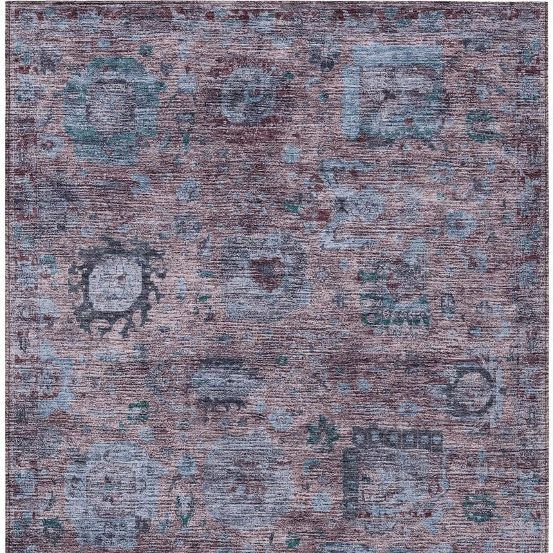 Abstract area rug with blue, plum, and light gray distressed blocks and teal specks