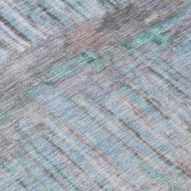 Abstract area rug surface detail with teal, taupe, and light gray diagonal brush lines
