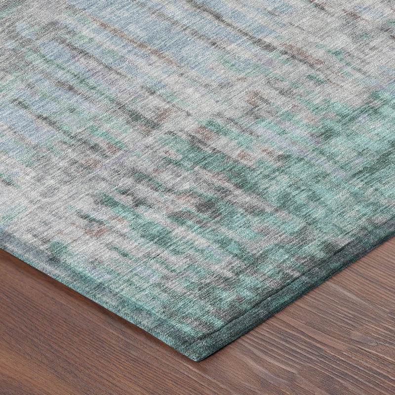 Teal and taupe abstract area rug corner with textured weave; placed on wood flooring