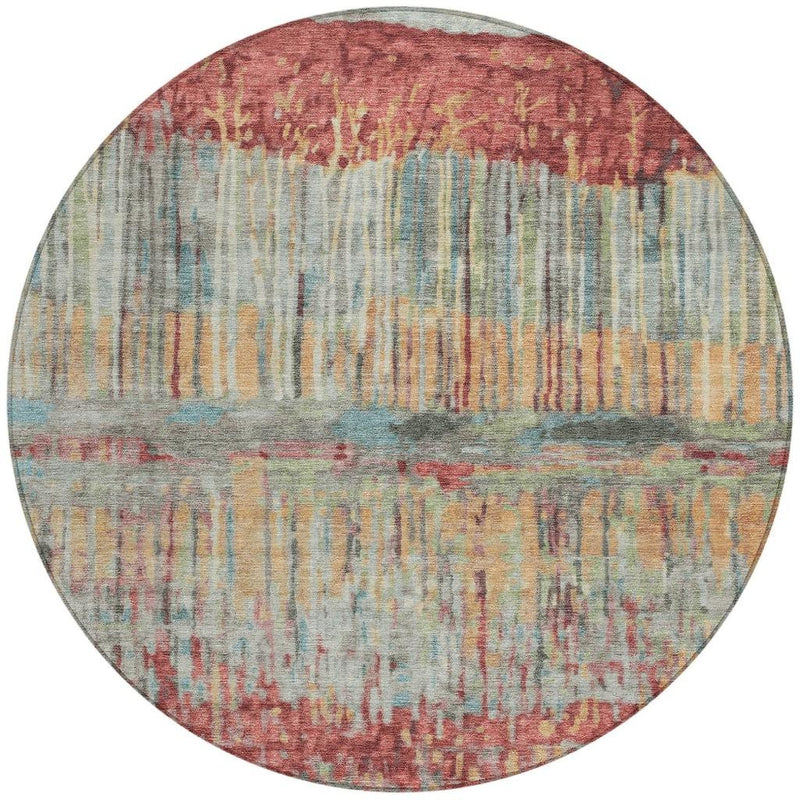 Round abstract area rug with coral, sage, blue, and gold faded vertical strokes.