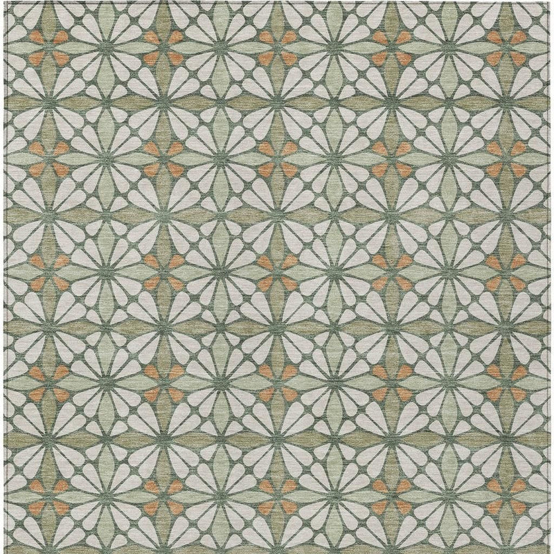 Close-up of geometric area rug pattern: cream ground with green and orange starburst motifs