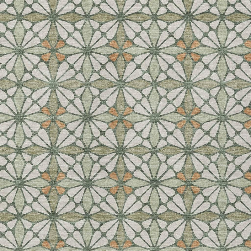 Patterned area rug surface with repeating starburst motifs in green, off-white, and orange