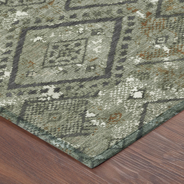 Geometric area rug with sage green base, dark pattern outlines, and small orange accents