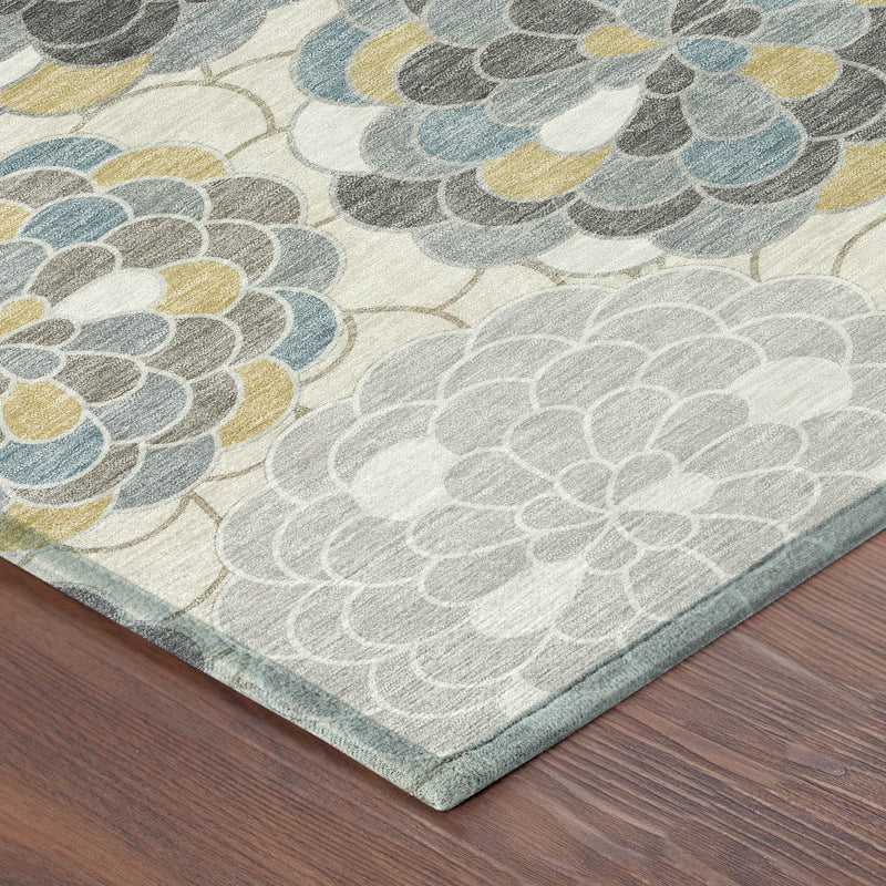 Corner of ivory area rug with gray, blue and yellow floral motifs and flat edge