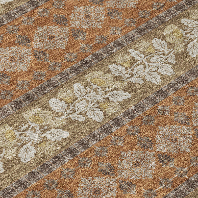 Striped rug detail in orange, beige, and gray with floral vines and medallions