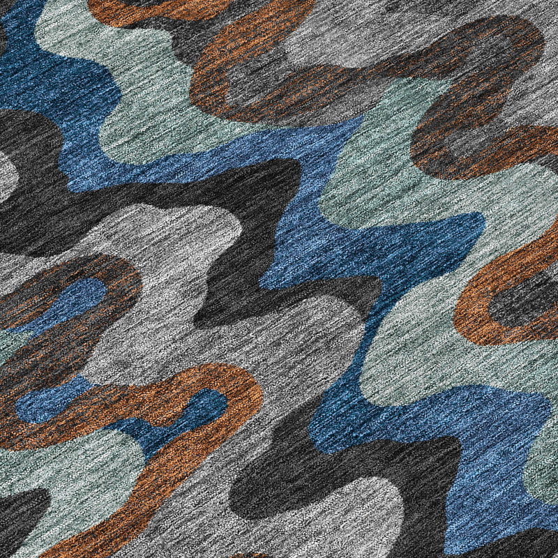 Close-up texture of abstract area rug with overlapping wavy shapes in blue, gray, and orange