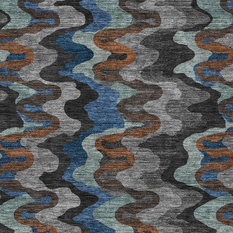 Close-up of abstract area rug showing wavy lines in charcoal gray with blue and orange