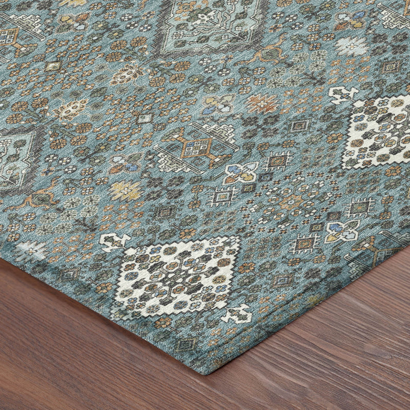 Teal blue geometric area rug corner on wood floor, ivory and gray pattern