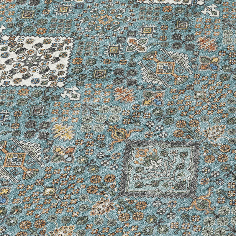 Teal blue geometric area rug close-up with ivory medallions and small motifs