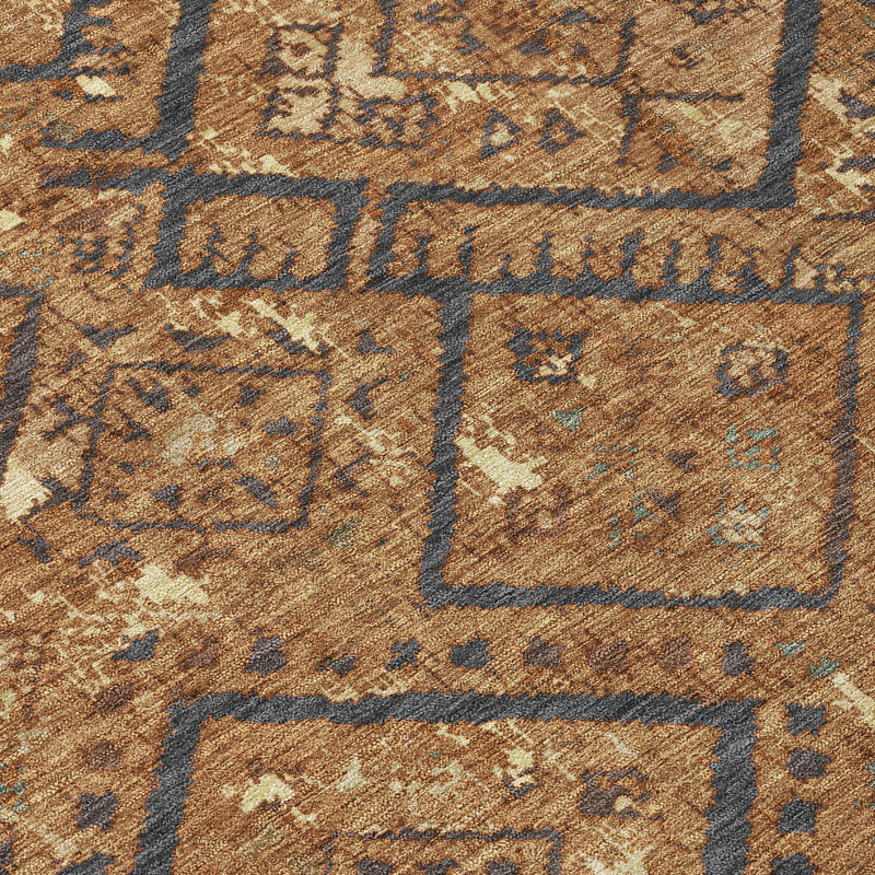 Close-up of orange and gold rug with blue diamond motifs and distressed texture