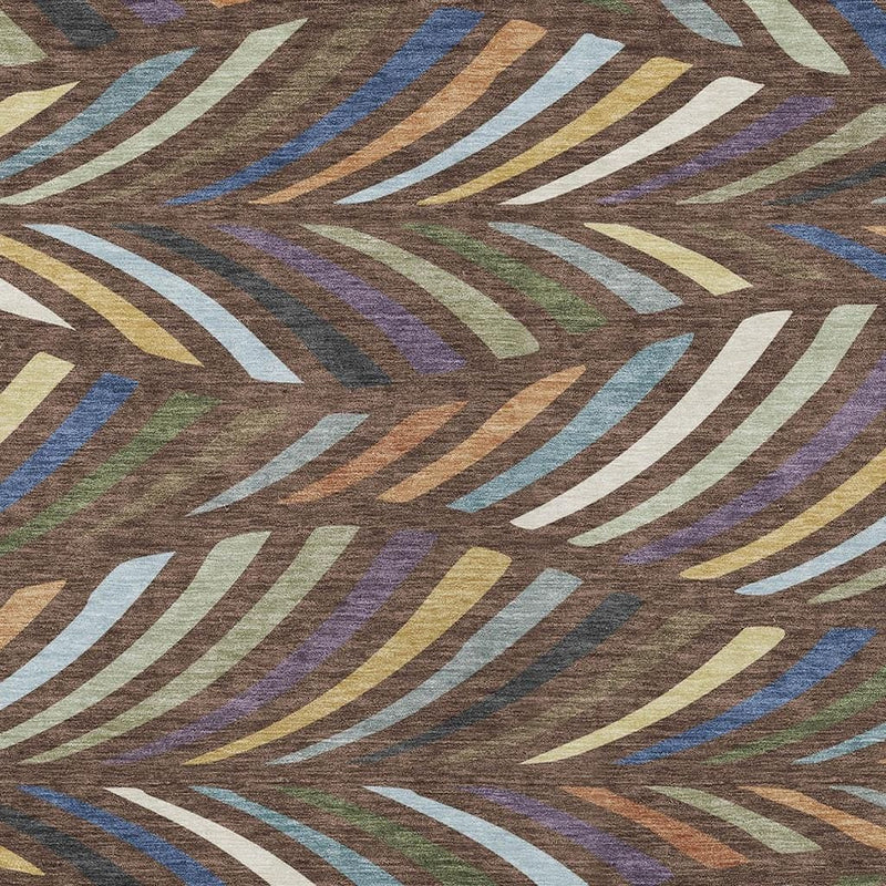 Close-up of area rug showing sweeping abstract stripes in blue, plum, green, and tan on brown