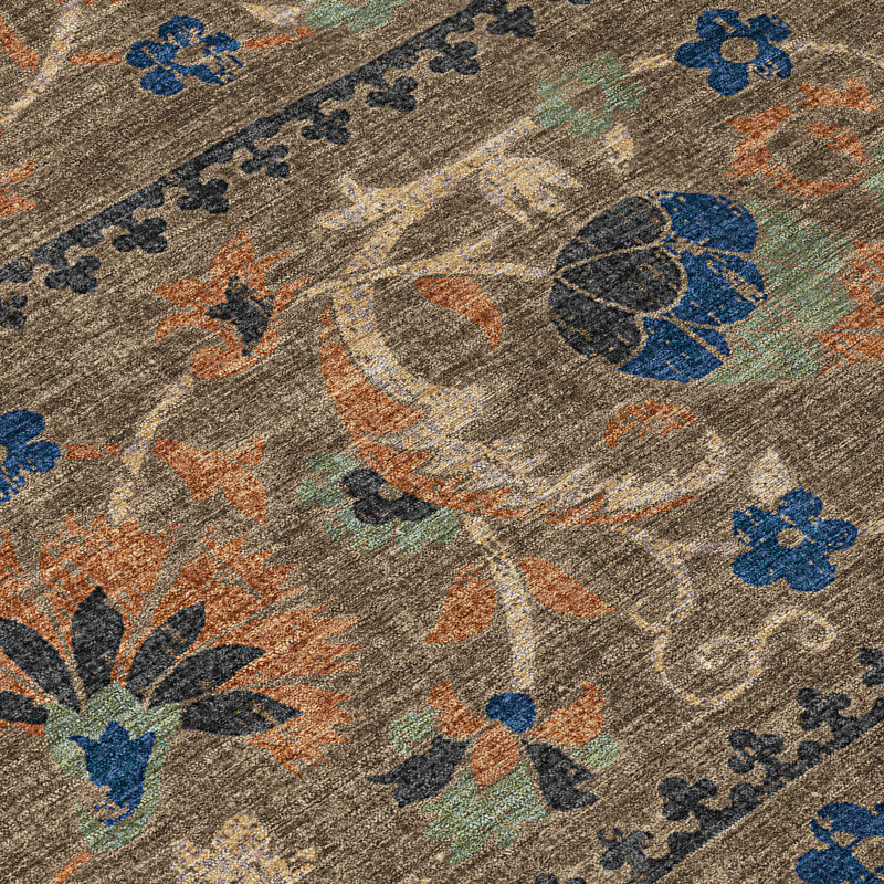 Close-up of floral ornamental area rug with blue, orange, and green accents on tan base