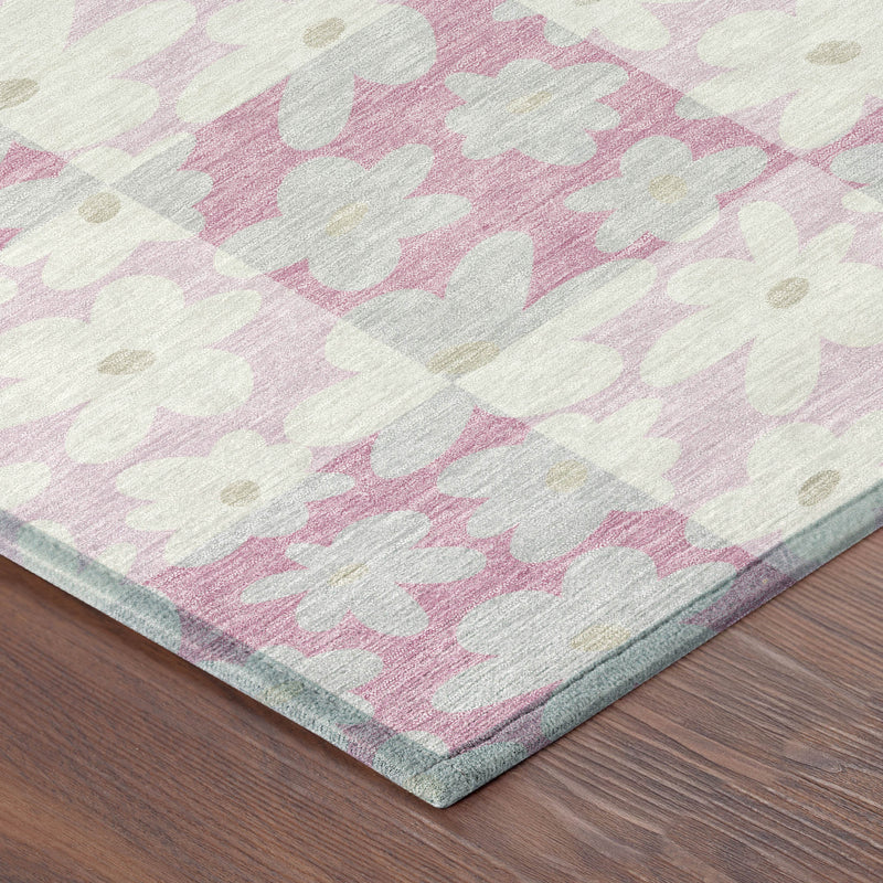 Corner detail of washable area rug with pink and gray floral pattern and light border