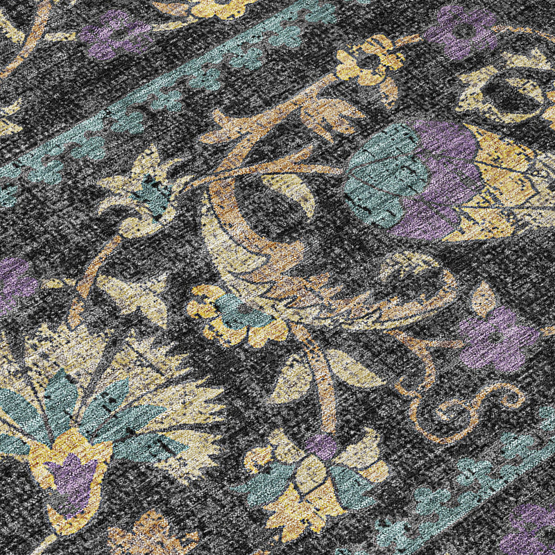 Distressed floral area rug close-up, dark charcoal with teal, purple, and gold motifs
