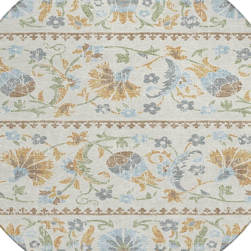 Close-up of round rug pattern: birds, flowers, and a tan ornamental border across ivory